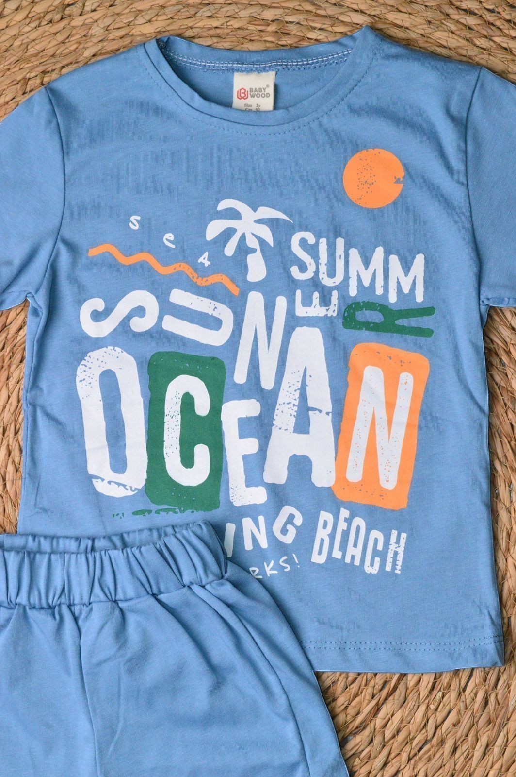 L'armoire De Yasmina blue cotton t-shirt and shorts set with "Summer Ocean" graphic print and palm tree
